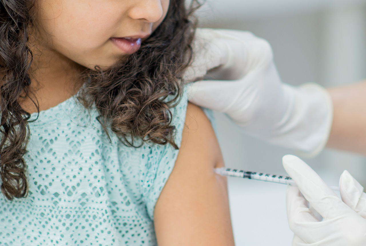 A child receiving a shot. A plastic medical product