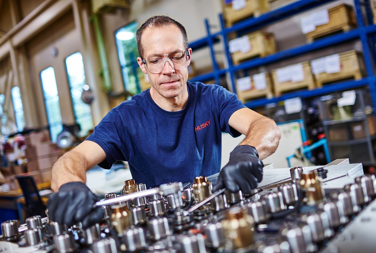 Husky Technician servicing a medical injection molding system